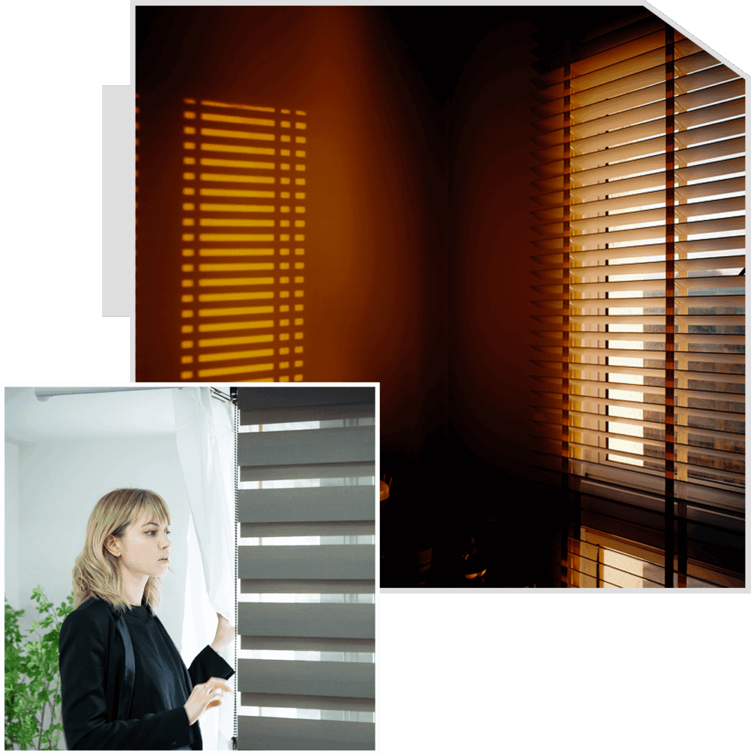 A woman standing in front of a window with blinds closed.