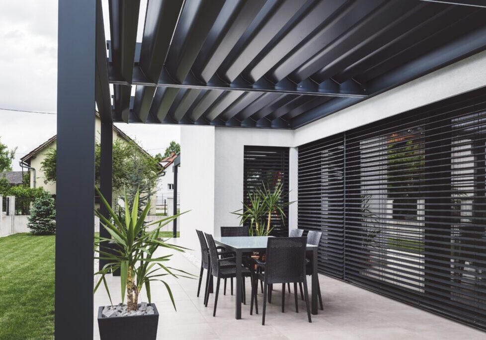 A patio with black furniture and white walls.
